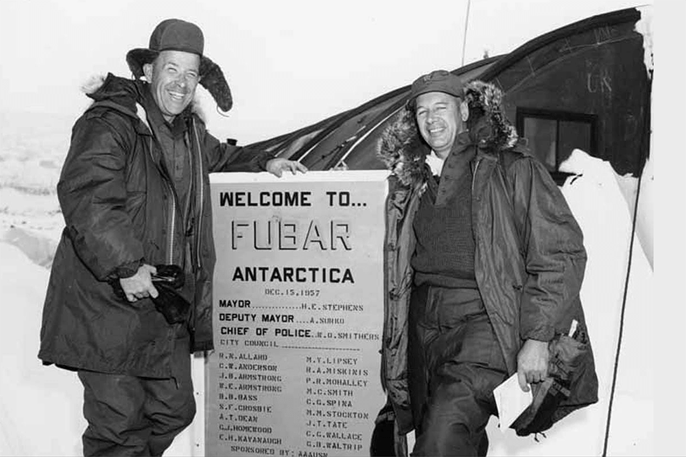 Senator Henry M. Jackson and Captain Heaman standing with a sign that says Welcome to...Fubar Antarctica, at Marble Point Base, Antarctica, October 16, 1959
