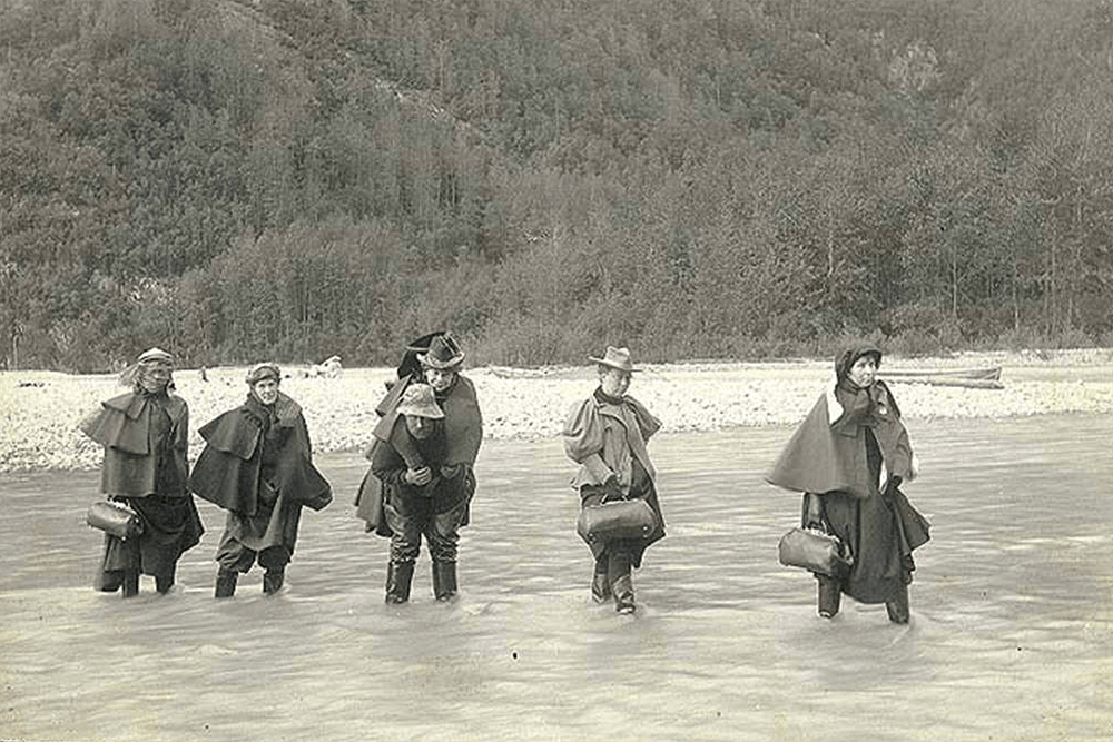 Actresses fording Dyea River on the Chilkoot Trail, Alaska, 1897